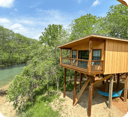 A wooden house sitting on top of a sandy beach.