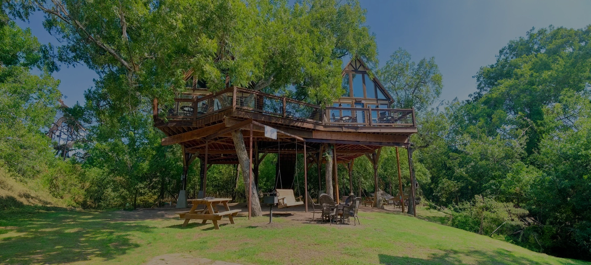 A wooden structure with benches and tables in the middle of it.