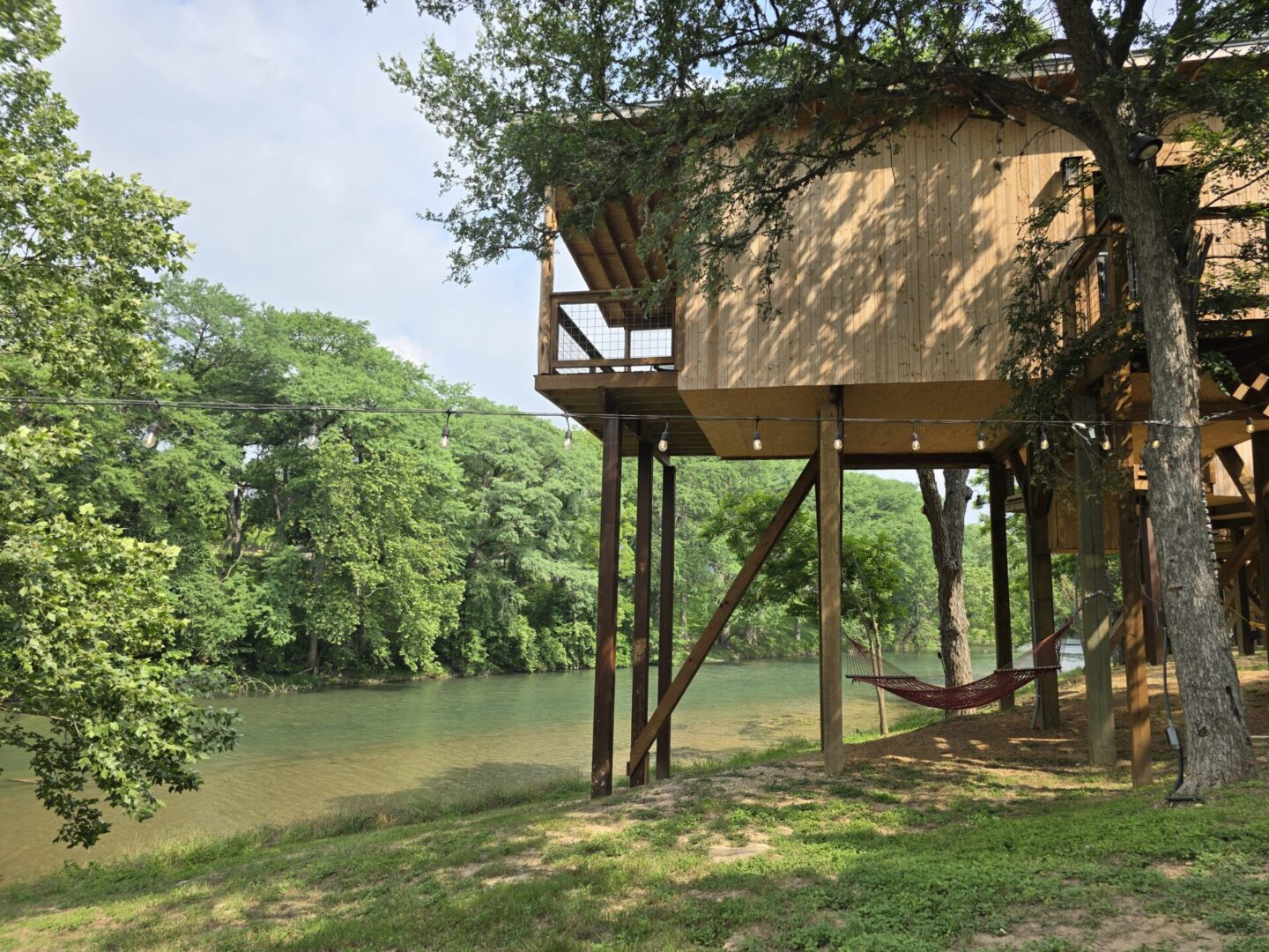 A tree house with a hammock in the middle of it.