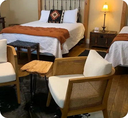 A bedroom with two beds and chairs in it