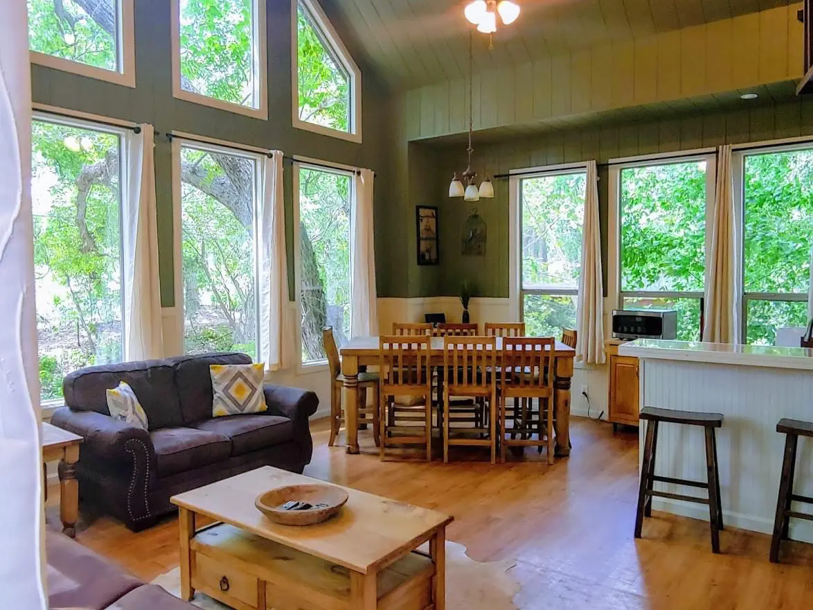 A living room with lots of windows and furniture.