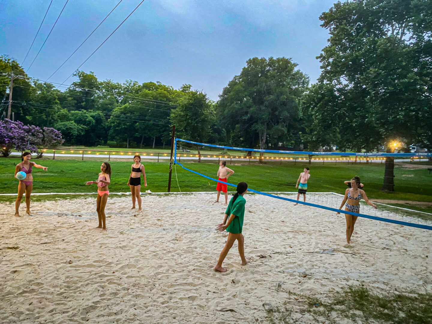 A group of people playing volleyball on the beach.