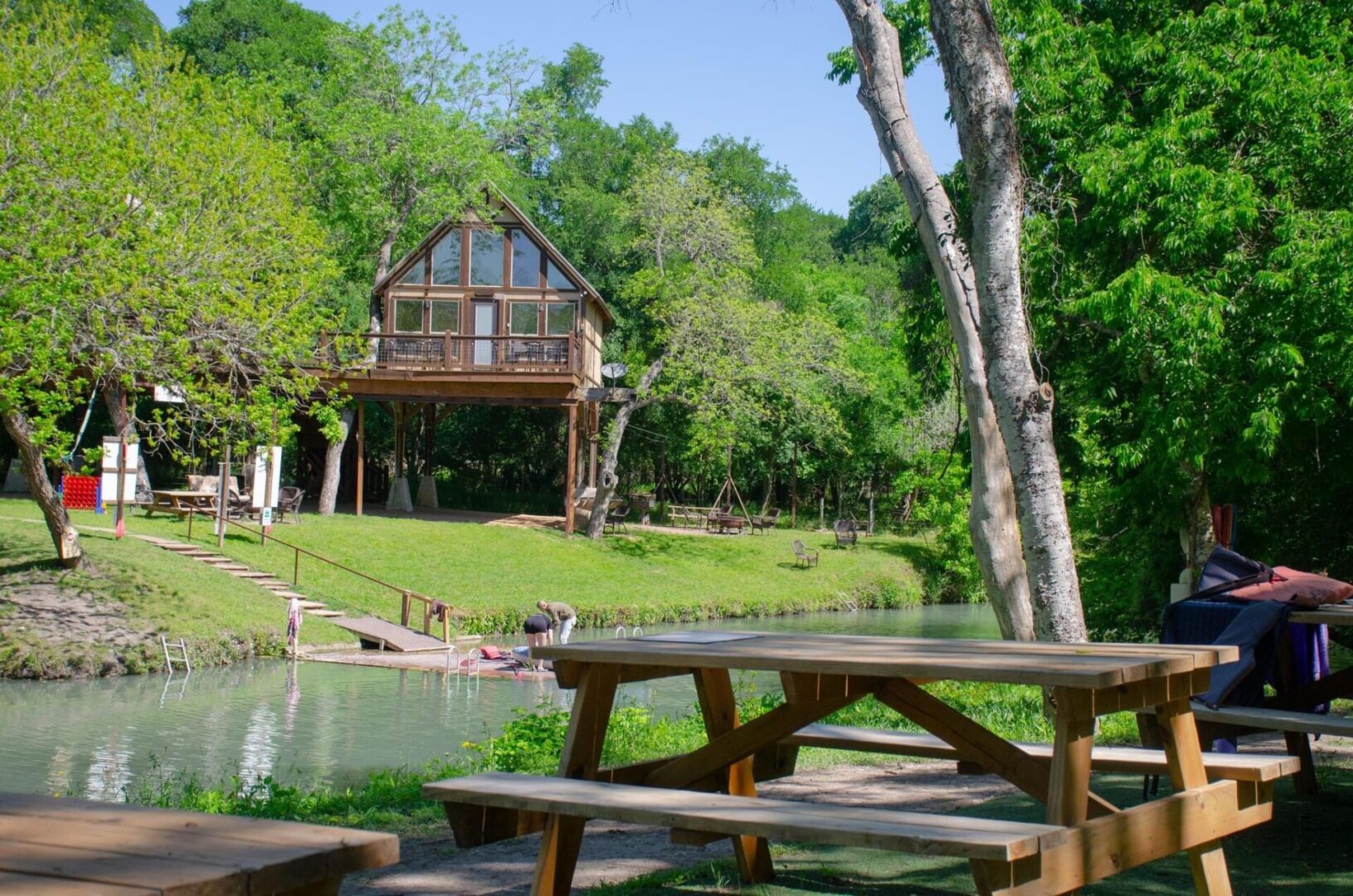 A wooden picnic table near the water.