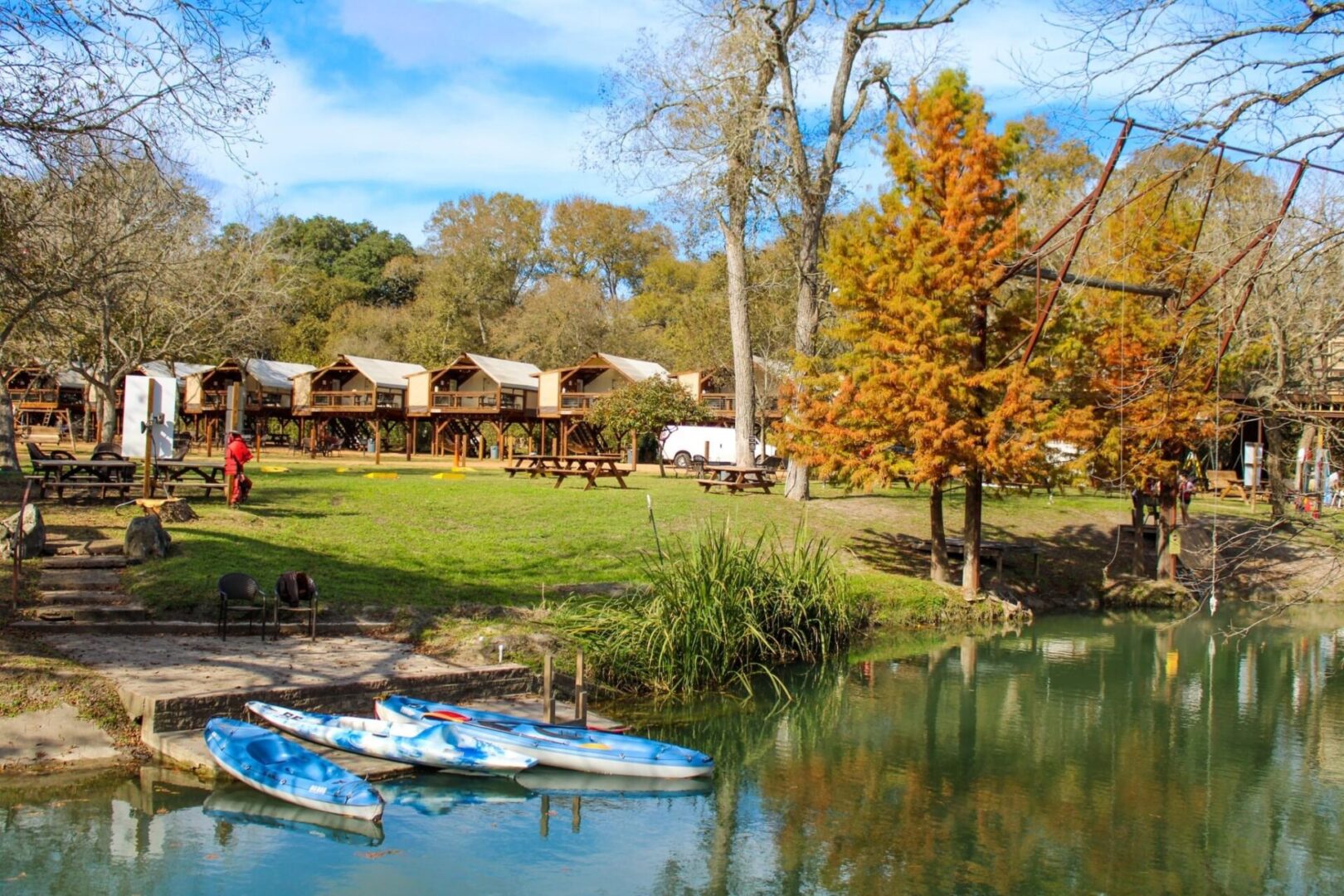 A group of boats in the water near some trees.