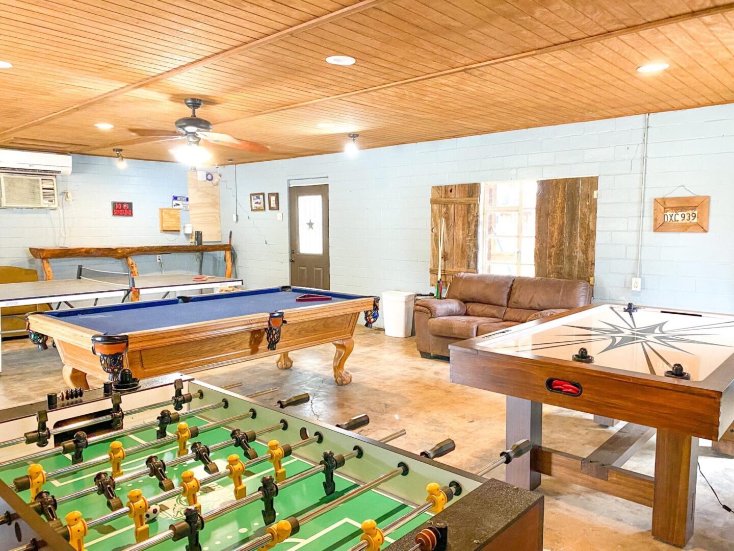 A room with two tables and a pool table.