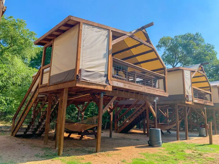 A wooden structure with two levels and a porch.