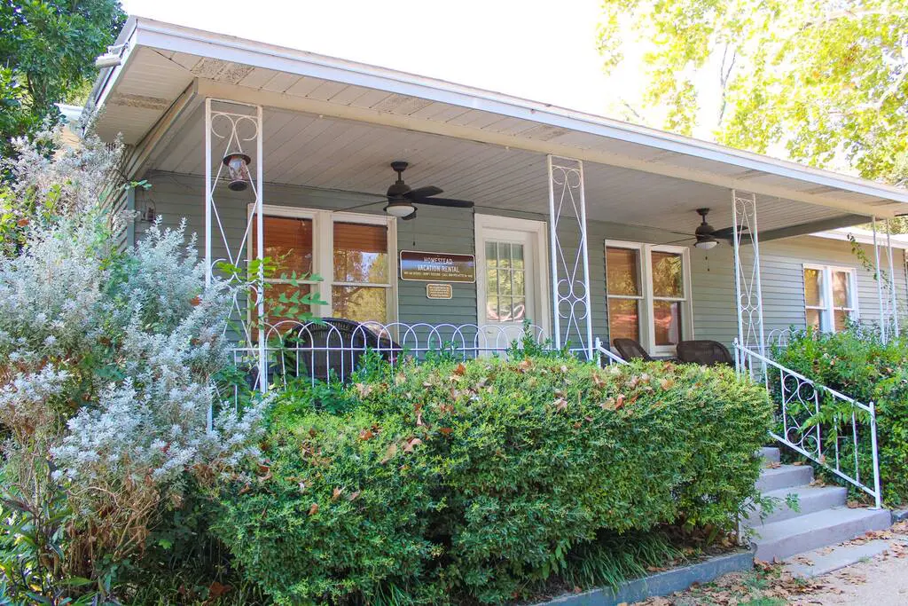 A house with bushes and trees in front of it