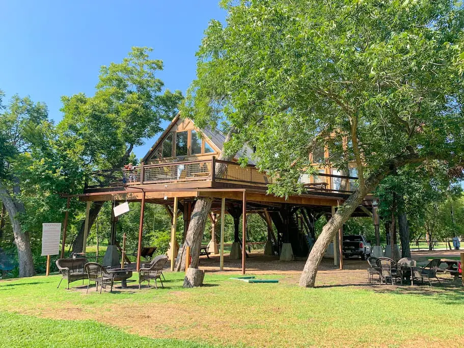 A large tree house with many chairs around it.