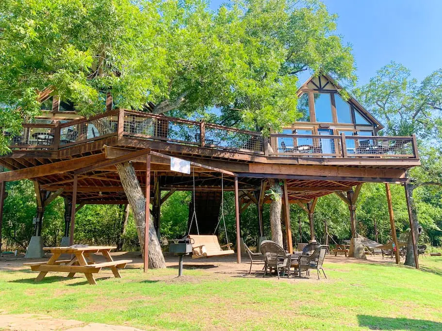 A wooden structure with benches and picnic tables.