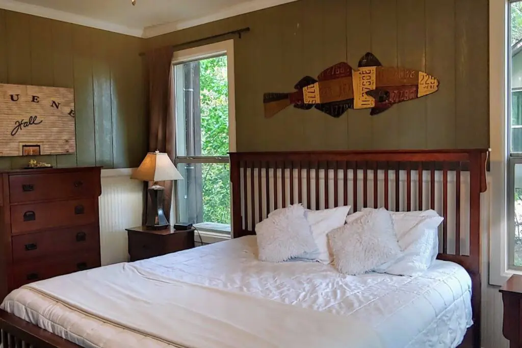 A bed room with a large white bedspread and pillows