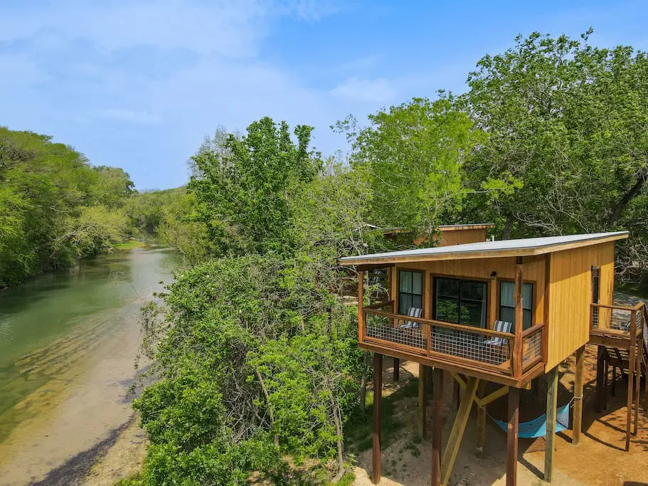 A house with a balcony and a river in the background.