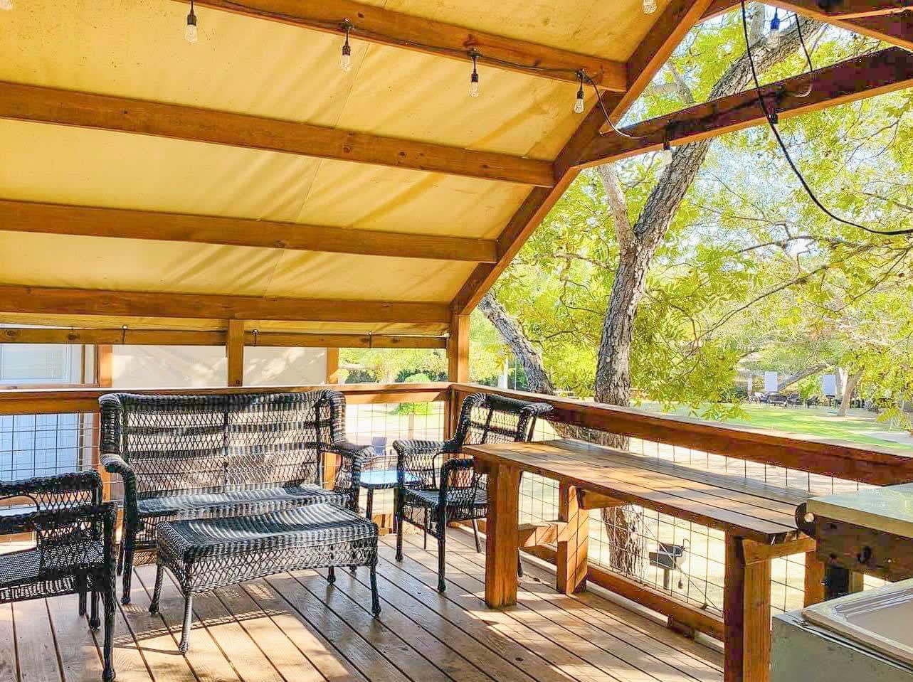 A wooden deck with chairs and tables on it.